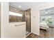 Bathroom shower with brown tiles, grab bar, and a window inside of the shower at 2585 Constance Ct, The Villages, FL 32163
