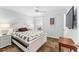 Cozy bedroom with a patterned quilt, side tables, and wood look floors at 2585 Constance Ct, The Villages, FL 32163