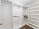 Spacious walk-in closet with built-in shelves and hanging rods for organized storage at 2585 Constance Ct, The Villages, FL 32163
