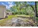 Grassy backyard with mature trees, patio, and a cozy seating area at 30342 Vitex Ave, Eustis, FL 32736