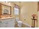 Charming powder room with decorative mirror, pedestal sink, toilet and window at 30342 Vitex Ave, Eustis, FL 32736