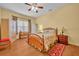Inviting bedroom features wood floors, floral bedding and natural light at 30342 Vitex Ave, Eustis, FL 32736