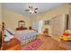 Comfortable bedroom with ceiling fan, wood floors, dresser and bright light at 30342 Vitex Ave, Eustis, FL 32736