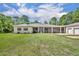 Sprawling ranch home with an oversized lawn, long porch, attached guest home, and three-car garage at 30342 Vitex Ave, Eustis, FL 32736