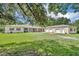 Sprawling ranch home with an oversized lawn, long porch, attached guest home, and three-car garage at 30342 Vitex Ave, Eustis, FL 32736