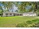 Sprawling ranch home with an oversized lawn, long porch, attached guest home, and three-car garage at 30342 Vitex Ave, Eustis, FL 32736