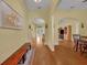 Sun-filled entryway with hardwood flooring, arched doorways, decorative art, and entry to various living spaces at 30342 Vitex Ave, Eustis, FL 32736