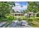 Inviting single-story home with a screened porch and ample yard space, framed by lush trees at 30342 Vitex Ave, Eustis, FL 32736