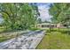 Charming single-story home with a long drive, lush greenery, and fenced front yard at 30342 Vitex Ave, Eustis, FL 32736