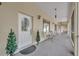 A charming front porch with concrete flooring, a white door, sconce lighting, and decorative flower pots at 30342 Vitex Ave, Eustis, FL 32736