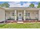 A charming front porch with concrete flooring, a white door, sconce lighting, and decorative flower pots at 30342 Vitex Ave, Eustis, FL 32736