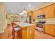 Open kitchen features a spacious island, stainless steel appliances, and light wood cabinetry at 30342 Vitex Ave, Eustis, FL 32736