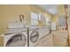 Bright laundry room with front loading washer and dryer, sink and cabinets at 30342 Vitex Ave, Eustis, FL 32736