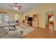 Inviting living room featuring hardwood floors, an oversized sofa, large tv, and natural light at 30342 Vitex Ave, Eustis, FL 32736