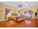 Spacious main bedroom with a ceiling fan, wood floors, and large windows at 30342 Vitex Ave, Eustis, FL 32736