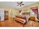 Large main bedroom featuring wood floors, ample natural light, and a cozy seating area at 30342 Vitex Ave, Eustis, FL 32736