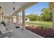 Open-air porch with slate flooring, views of lawn, landscaping, detached garage, and outdoor seating area at 30342 Vitex Ave, Eustis, FL 32736