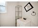 Small bathroom with a sink, mirror, shelving, and a window at 31136 Senese Rd, Sorrento, FL 32776