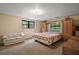 Spacious bedroom with built-in cabinets, two windows, and a comfortable seating area at 31136 Senese Rd, Sorrento, FL 32776