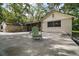 Charming home featuring a concrete patio with mature trees and a view of the adjacent lawn at 31136 Senese Rd, Sorrento, FL 32776