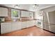 Bright kitchen with white cabinets, stone accent wall, modern appliances, and wood-look flooring at 31136 Senese Rd, Sorrento, FL 32776