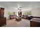 Inviting living room featuring plush seating, carpeted floors, large windows, and a cozy fireplace at 31136 Senese Rd, Sorrento, FL 32776