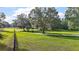 Lush green lawn with trees on a large property with a home in the background on a sunny day at 31136 Senese Rd, Sorrento, FL 32776