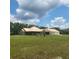 Expansive green lawn surrounds this ranch-style home with metal roof and screened patio at 3147 Rambler Ave, St Cloud, FL 34772