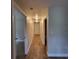Well-lit hallway with wood-look flooring connects rooms in the home at 3147 Rambler Ave, St Cloud, FL 34772