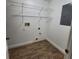 Bright laundry room with wood-look floors, metal shelving, and utility hookups at 3147 Rambler Ave, St Cloud, FL 34772