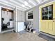 Enclosed back porch with yellow door, deep freezer, washer, and dryer at 326 N Lancelot Ave, Orlando, FL 32835