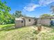 Spacious backyard with a storage shed, green grass and mature trees on a sunny day at 326 N Lancelot Ave, Orlando, FL 32835
