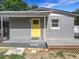 Charming home with a bright yellow front door, gray siding, and a cozy porch at 326 N Lancelot Ave, Orlando, FL 32835