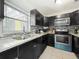 Modern kitchen featuring stainless steel appliances, granite countertops, and elegant dark cabinetry at 326 N Lancelot Ave, Orlando, FL 32835