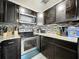 Stylish kitchen with stainless steel appliances, dark cabinets, and tiled backsplash at 326 N Lancelot Ave, Orlando, FL 32835