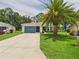 Charming single-story home with a well-maintained lawn and a vibrant palm tree in the front yard at 32701 Timberwood, Leesburg, FL 34748