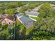 Aerial view of home with screened-in patio and fenced yard within a wooded neighborhood at 33316 Irongate Dr, Leesburg, FL 34748