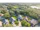 Aerial view shows property's yard, fencing, and surrounding tree-lined neighborhood near lake at 33316 Irongate Dr, Leesburg, FL 34748