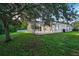 A large grassy backyard with a covered patio featuring backyard privacy fence at 33316 Irongate Dr, Leesburg, FL 34748
