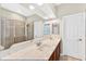 Bright bathroom boasts double sinks, a large mirror, and a glass-enclosed shower at 33316 Irongate Dr, Leesburg, FL 34748