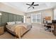 Bright bedroom features a ceiling fan, a large window, and a stylish accent wall at 33316 Irongate Dr, Leesburg, FL 34748