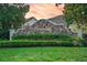 Stonegate community entrance featuring stone details, mature landscaping, and lush green grass at 33316 Irongate Dr, Leesburg, FL 34748