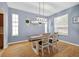 Cozy dining room with a modern chandelier, wood floors, and natural light at 33316 Irongate Dr, Leesburg, FL 34748