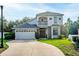 Charming two-story home featuring a balcony, stone accents, a well-manicured lawn, and a two car garage at 33316 Irongate Dr, Leesburg, FL 34748