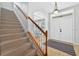 Inviting foyer with staircase, wood railing, and tile flooring at 33316 Irongate Dr, Leesburg, FL 34748