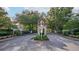 Gated entrance to a community with mature trees and landscaping, offering security and privacy at 33316 Irongate Dr, Leesburg, FL 34748