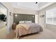 Cozy main bedroom features a tray ceiling, stylish sconces, and access to a walk-in closet at 33316 Irongate Dr, Leesburg, FL 34748