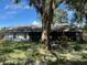 Backyard featuring a screened-in patio and mature trees providing shade at 35219 Haines Creek Rd, Leesburg, FL 34788