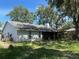 Backyard view featuring a screened-in patio with mature trees offering shade at 35219 Haines Creek Rd, Leesburg, FL 34788