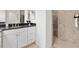 Elegant bathroom featuring a granite countertop, white cabinets and a luxurious tiled walk-in shower at 3566 Gentle Ter, The Villages, FL 32163